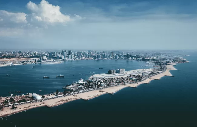 Aerial view of Luanda with its modern coastline, tall buildings, and a narrow peninsula.