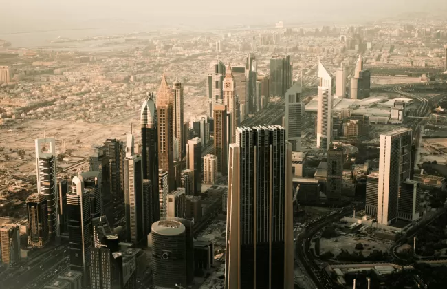 Skyline of Dubai with tall modern skyscrapers in golden light.