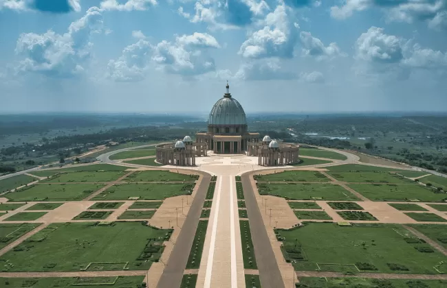 A wide boulevard leading to a large monument surrounded by open lawns.