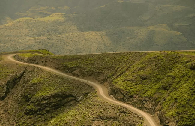 Rolling green hills and dirt roads stretching into the distance.