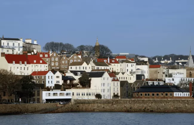 A coastal town with white houses and red roofs along the shoreline.