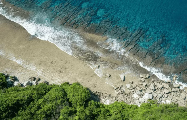 A sandy beach with turquoise waves meeting the shore.