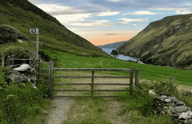 A peaceful countryside path through rolling green hills on the Isle of Man.