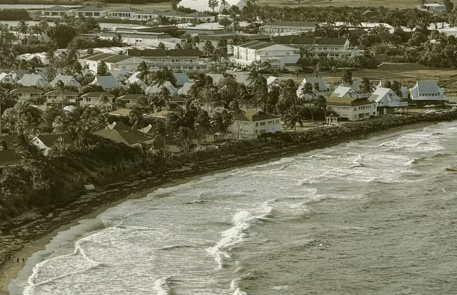 Sepia-toned coastal town with waves breaking onshore.