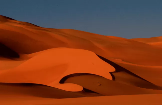 Orange sand dunes in the desert.