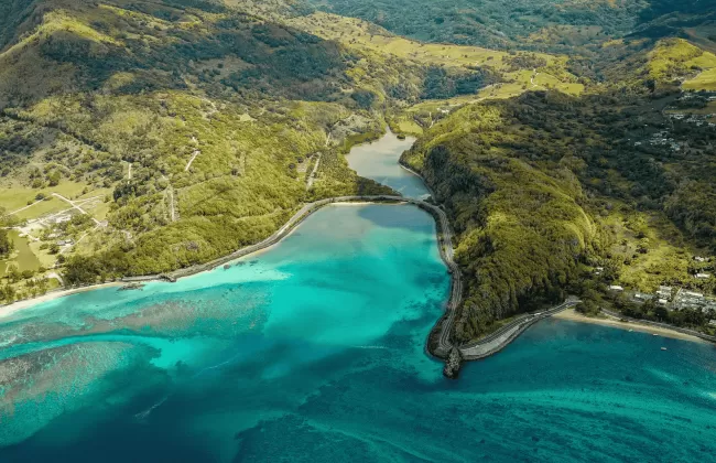 Aerial view of a lush island with turquoise lagoon.