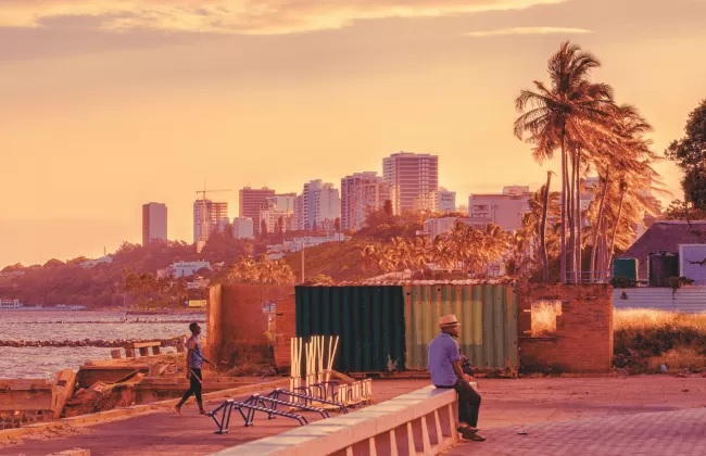 City scene with palm trees and colorful buildings.