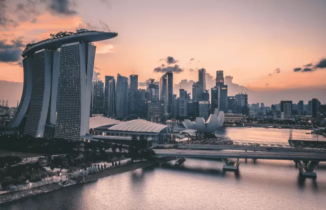 Modern skyline of Singapore with Marina Bay Sands at sunset.