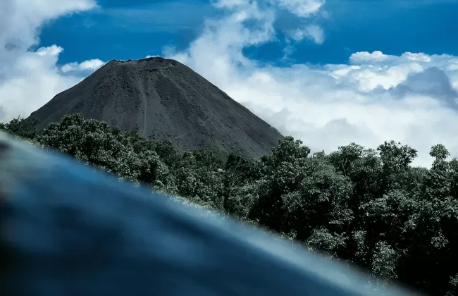A volcanic crater with a blue lake seen from above.