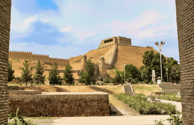 Ancient fortress ruins with stone walls under a blue sky.