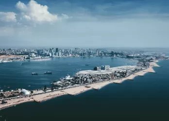 Aerial view of Luanda with its modern coastline, tall buildings, and a narrow peninsula.