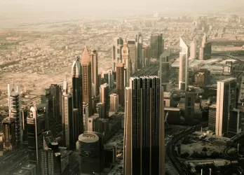 Skyline of Dubai with tall modern skyscrapers in golden light.
