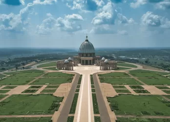 A wide boulevard leading to a large monument surrounded by open lawns.