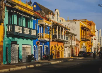 A vibrant street lined with colorful colonial-style houses and shops.