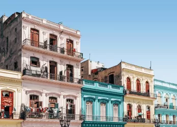 Colorful colonial-style buildings with balconies along a street.