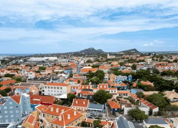 coastal town with red-roofed houses near the ocean.