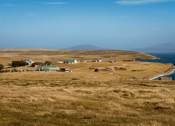 Dry grassy plains with sparse settlements near the coastline.