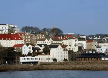 A coastal town with white houses and red roofs along the shoreline.