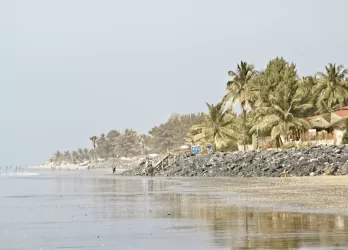 A coastline with calm shallow water and houses on the shore.