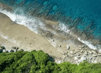 A sandy beach with turquoise waves meeting the shore.