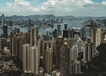 A dense skyline of tall buildings in Hong Kong, viewed from above.