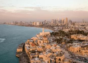 A coastal cityscape of Tel Aviv, Israel, with modern buildings along the Mediterranean.