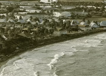 Sepia-toned coastal town with waves breaking onshore.