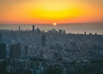 Sunset view over a large city with tall skyscrapers.