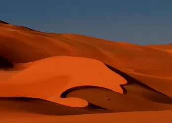 Orange sand dunes in the desert.