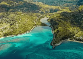 Aerial view of a lush island with turquoise lagoon.